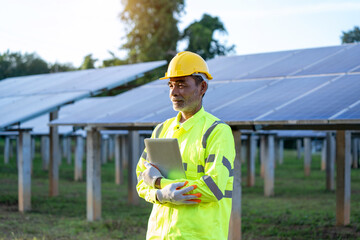 Poster - Supervisor Engineers men wearing safety vest and safety helmet standing in front of solar panels,Green Energy Concept.