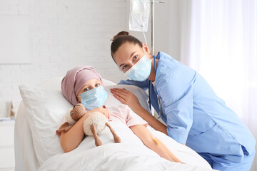 Wall Mural - Nurse and little girl undergoing chemotherapy course in clinic