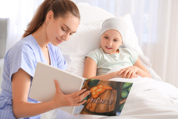 Poster - Woman reading book to her daughter who is undergoing course of chemotherapy in clinic. Childhood cancer awareness concept