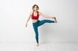 © SHOTPRIME STUDIO - A woman in full growth In a bright room yoga meditation is engaged in sports