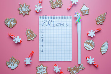  Holiday decorations and notebook with 2021 goals, plans, dreams. New Year and Christmas concept. Flat lay. Top view.