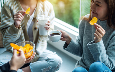 Wall Mural - Closeup image of friends drinking and eating potato chips together