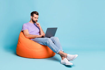 Poster - Full length body size photo of confident businessman working on computer in beanbag isolated on vibrant blue color background copyspace