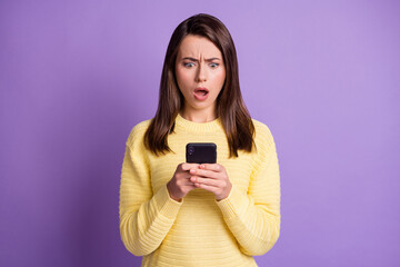 Canvas Print - Photo portrait of upset nervous girl holding phone in two hands with open mouth isolated on vivid violet colored background