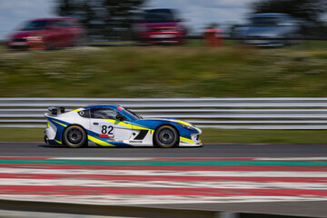 Wall Mural - A panning shot of a racing car as it circuits a track.