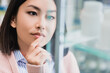© LIGHTFIELD STUDIOS - pensive asian customer looking at bottle with medication on blurred foreground