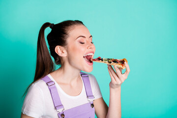 Sticker - Side profile photo portrait of hungry girl with tails eating tasty pizza with closed eyes isolated on bright turquoise color background