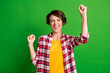 Portrait of charming satisfied person fists up closed eyes yell yeah checkered clothing isolated on green color background