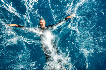 Poster - Man splashing in the ocean water, holiday concept, diving in the sea