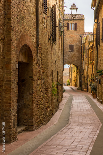 Fotomural The empty narrow winding back street of a historic hilltop town in Tuscany Italy