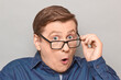 © Andrei Korzhyts - Portrait of shocked man peering over glasses at something unbelievable