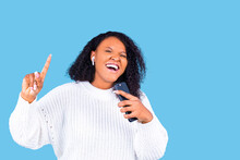 african american woman isolated on blue background in studio Listen music with earpods