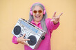Happy senior woman dancing and holding vintage stereo - Focus on face