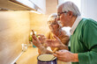 © Dragana Gordic - Senior couple having fun in home kitchen. Elderly retired couple reading their social media news on a smartphone in a fresh white kitchen as they enjoy a relaxing retirement