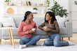 © Prostock-studio - Smiling african american besties having conversation while drinking coffee