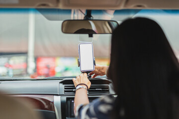 Wall Mural - Woman driver hand adjust cell phone for direction.