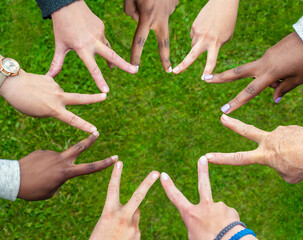 Black and white people forming nine pointed star with their fingers.