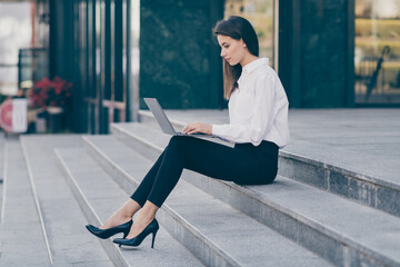 Canvas Print - Full length photo of cute pretty young lady dressed white formal shirt high-heels typing modern gadget sitting stairs outside