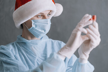 Wall Mural - doctor in medical mask and santa on gray background with place for text