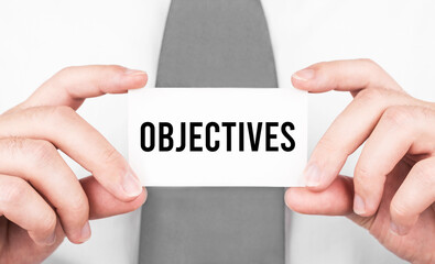 Fototapete - Businessman holding a card with text OBJECTIVES,business concept