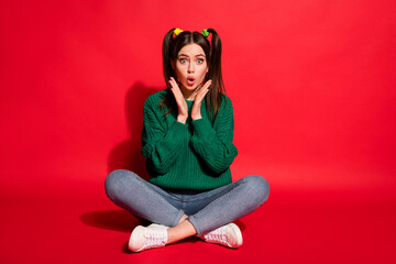 Poster - Full size photo of young attractive shocked amazed surprised girl sit floor crossed legs isolated on red color background