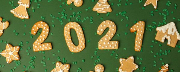 Wall Mural - Winter Holiday banner- set of gingerbread on natural green background - Number Happy New Year 2021, house, stars and xmas tree sprinkles, Merry Christmas background, trendy concept, flyer, invitation