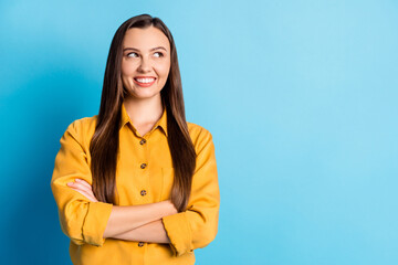 Photo of nice sweet brunette lady crossed arms look empty space wear yellow outfit isolated on teal background