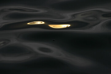 Black sea water and golden water exposed to the afternoon sun form a beautiful abstract background