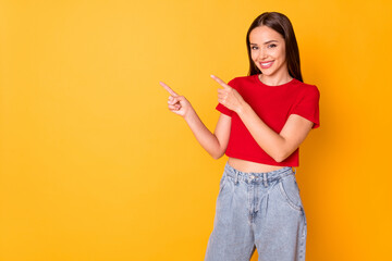 Wall Mural - Photo of attractive lady direct index fingers side empty space wear casual red top jeans isolated over yellow color background