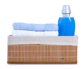 Wall Mural - Blue laundry softener in plastic bottle and stack folded towels in laundry basket on white background isolation