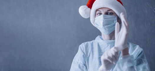 Wall Mural - doctor in medical mask and santa on gray background with place for text