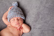 © IdeaBug, Inc. - Newborn Baby Sleeping Peacefully in Knit Hat, Room for Text on Right