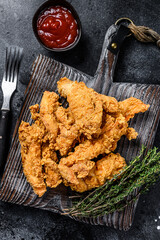 Wall Mural - Steak Fingers fried breaded chicken breast strips. Black background. Top view