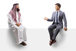 © Ljupco Smokovski - Saudi arab man and a young man in a suit sitting on a blank board and talking