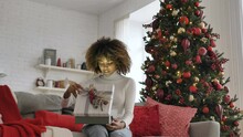 Young Woman With Short Kinky Hair Holds Box On Knees And Opens Present With Bright Light Inside Illuminating Face Slow Motion