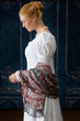 A Regency woman wearing a white muslin dress standing alone in a room