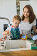 mother and son wash dishes together.