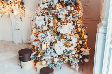 Classic christmas New Year decorated interior room New year tree. Christmas tree with gold decorations and gift boxes. Modern white classical style interior design apartment. Christmas eve at home.