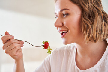 Woman stretching a fork with salad t