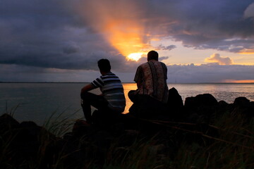 two friends are enjoying sunset on ganges river, diamond harbour, west bengal in india