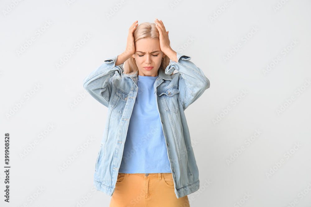 Stressed young woman on grey background
