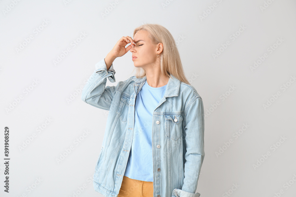 Stressed young woman on grey background