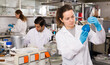 © JackF - Focused woman lab technician working with reagents in test tubes during chemical experiment..