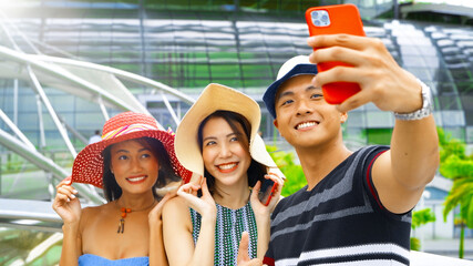 Sticker - Three asian young friends enjoy outdoor time taking selfies in the city