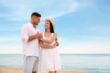 Canvas Print - Lovely couple dancing on beach near sea. Space for text