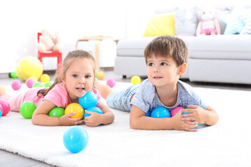 Poster - Cute little children playing with toys on floor at home