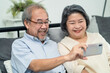 © Kawee - Asian senior couple making video call via smartphone with their child.