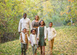 © Brocreative - Cute mixed race family portrait outdoors. Walking together in nature with the fall colors in the background. A candid photo of Smiling, happy, diverse multi ethnic family