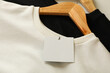 © Atlas - Hangers with stylish sweatshirts and blank tag, close up