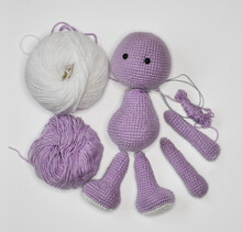Parts Of A Knitted Purple Bear On White Background. Handmade Crochet Toy. Amigurumi
